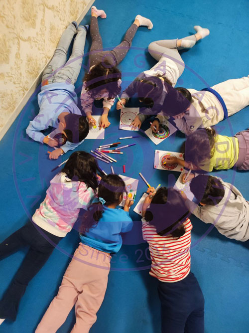 کودکان در کلاس یوگا مشغول رنگ آمیزی ماندالا 