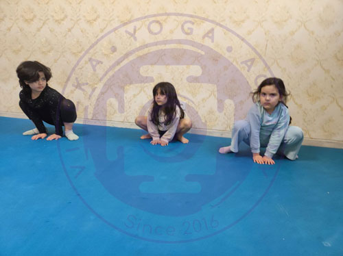 کودکان در کلاس یوگا در وضعیت مالاسانا